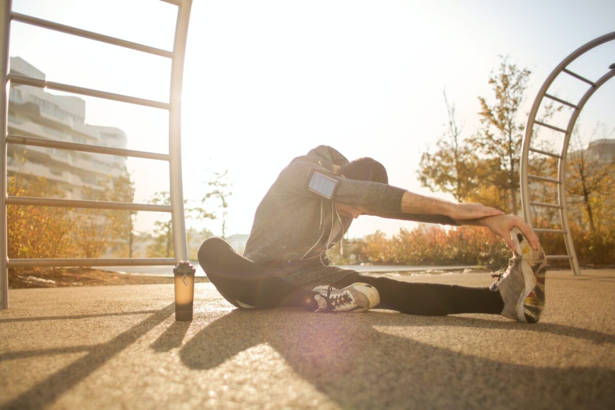 A man sitting on the floor and stretching.