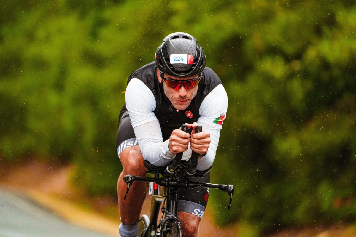 Man on a bicycle riding through the rain.